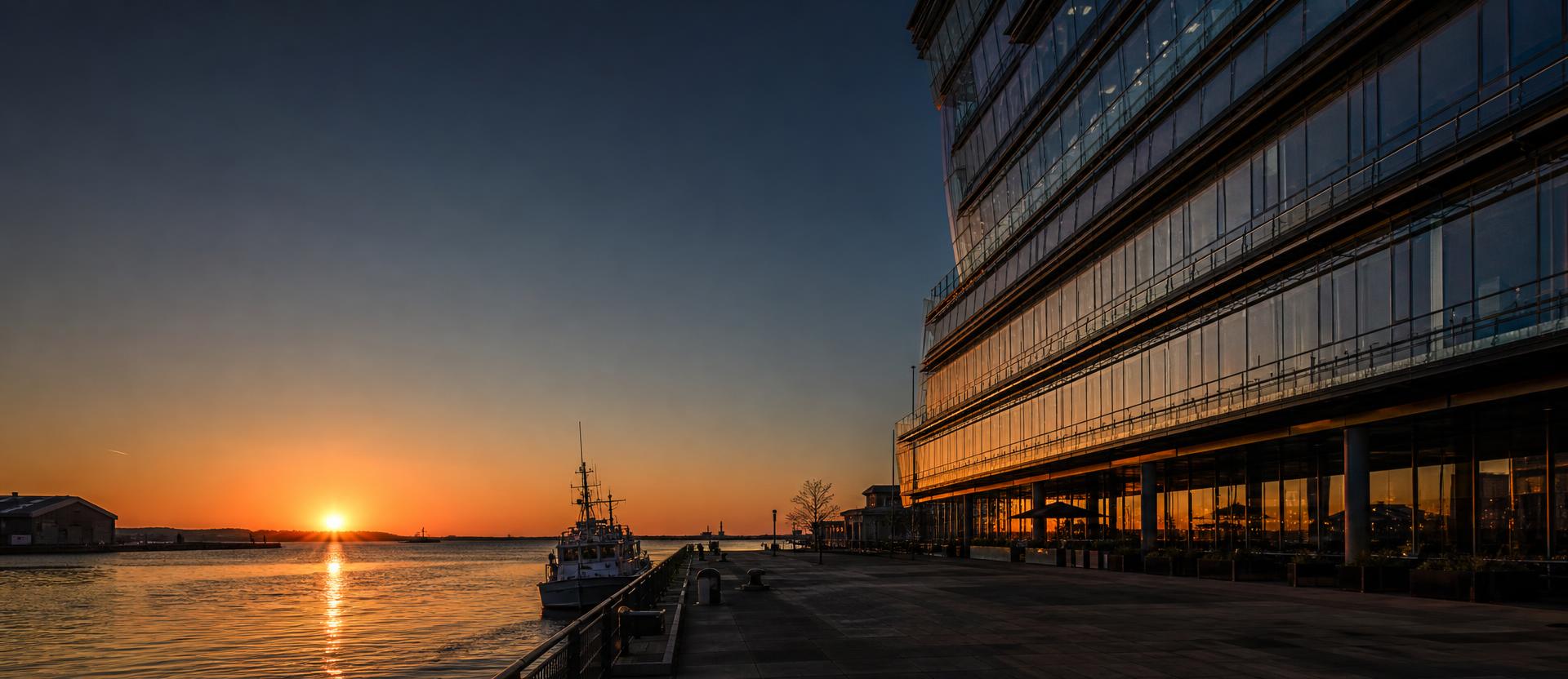 Harbourside architecture at dusk, low golden light across the water
