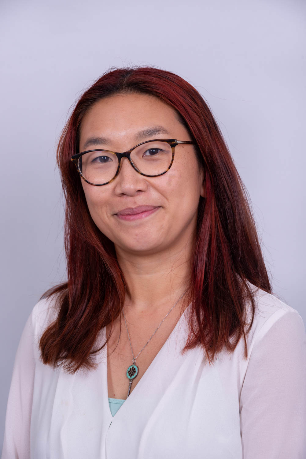 Corporate headshot of a professional on a light grey studio backdrop